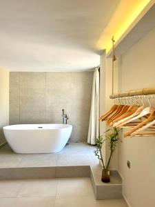 Habitación con baño con bañera blanca grande. en Pool Villa Lagonisi 5min from Beach, en Koropíon