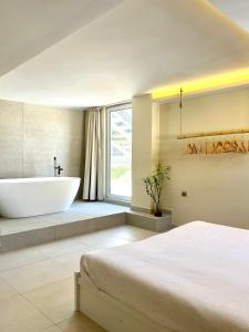 baño con bañera, cama y lavamanos en Pool Villa Lagonisi 5min from Beach, en Koropíon
