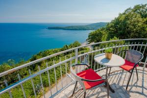 d'une table et de chaises sur un balcon avec vue sur l'océan. dans l'établissement SunSeoce Apartments, à Budva