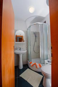 La salle de bains est pourvue d'une douche, d'un lavabo et de toilettes. dans l'établissement SunSeoce Apartments, à Budva