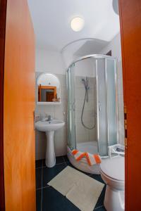 ブドヴァにあるSunSeoce Apartmentsのシャワー、洗面台、トイレ付きのバスルーム