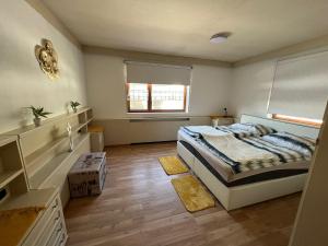 a bedroom with a bed and a window at Sandys Ferienwohnung im Grünen in Niederdorf