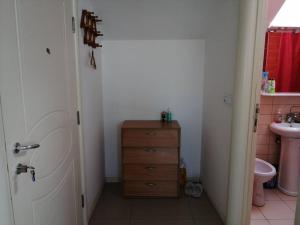 a bathroom with a sink and a wooden dresser at Apartman Nataša 3 in Vršac