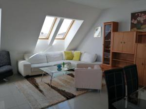 a living room with a white couch and a table at Apartman Nataša 3 in Vršac