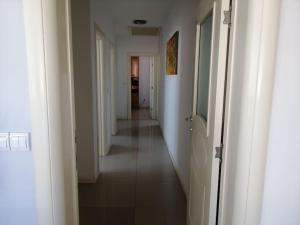 a long hallway with white walls and a long white floor at Apartman Nataša 3 in Vršac