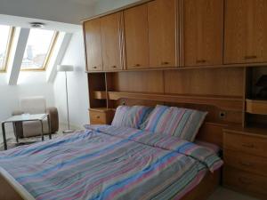 a bedroom with a bed with wooden cabinets at Apartman Nataša 3 in Vršac +28 photos