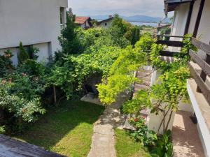 an apartment garden with plants and a balcony at Villa Sofia in Chernomorets