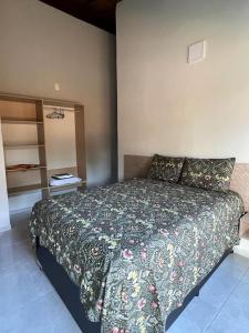sypialnia z dużym łóżkiem z narzutą kwiatową w obiekcie Fabulous 5 bedroom villa in Japaratinga w mieście Japaratinga