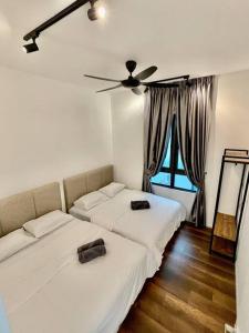 - une chambre avec 2 lits et un ventilateur de plafond dans l'établissement Onsen Suits HJM @ Sunway Ipoh, à Ipoh