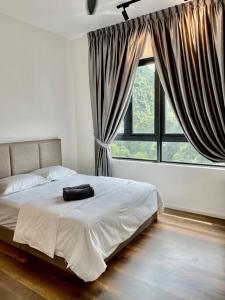 een bed in een slaapkamer met een groot raam bij Onsen Suits HJM @ Sunway Ipoh in Ipoh