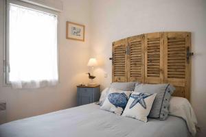 1 dormitorio con 1 cama con cabecero de madera en Appart cosy 4/6 personnes idéalement placé, en Aytré
