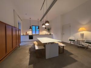 a living room with a table and a kitchen at Historisches Designer Loft in Essen