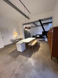 un soggiorno con tavolo, panca e pianoforte di Historisches Designer Loft a Essen Altre 33 foto
