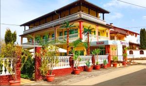 a house with palm trees in front of it at Комплекс за гости "Тера Верде" in Oreshak