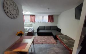 un soggiorno con divano e orologio sul muro di Brodovskiy- Apartment a Neckarsulm