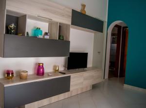 a living room with a tv on a wall at MADACHI APPARTAMENTI in Trapani