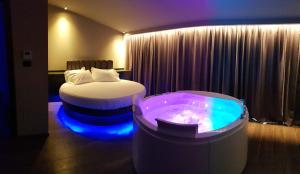 Leoni Hotel & Private Spa - LOVE HOTEL في شيتا سانت أنجيلو: غرفة الفندق بسرير وحوض استحمام
