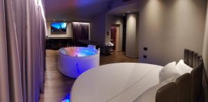 a room with a tub with a table and a tv at Leoni Hotel & Private Spa in Citta' Sant'Angelo