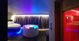 Leoni Hotel & Private Spa - LOVE HOTEL في شيتا سانت أنجيلو: غرفة نوم بسرير وغرفة ذات اضاءة زرقاء