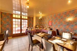 Un comedor con mesas y sillas en un restaurante. en Logis Auberge des Vieux Chenes, en Malemort-sur-Corrèze 6 fotos más