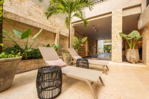 Duas cadeiras e uma mesa num pátio com piscina em Madisson Boutique Hotel Cartagena em Cartagena de Indias