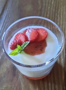 a bowl of yogurt with strawberries on a table at Chambres d’hôtes La Joyeuse in Préveranges
