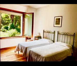 2 camas en un dormitorio con ventana en IlPoggetto Bed&Breakfast, en Civitanova Marche