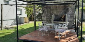 un patio con mesa, sillas y chimenea en Casa en el Real de san carlos en Colonia del Sacramento