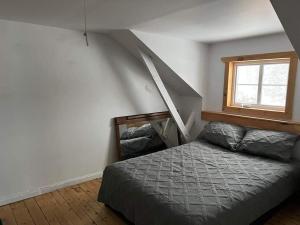 Schlafzimmer mit einem Bett und einem Fenster in der Unterkunft Résidences touristiques l’Abris in LʼAnse-Saint-Jean