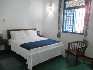 カルタラにあるVilla Whispering Shellsのベッドルーム1室(ベッド1台、椅子、窓付)