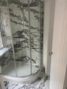 a shower with a glass enclosure in a bathroom at Modern welsh cottage in Porth