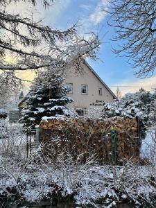 a house is covered in snow in front of a fence at Domek w Karkonoszach in Karpacz