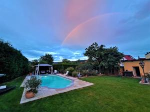 a rainbow over a yard with a swimming pool at Apartamento Maria in Kleinheubach