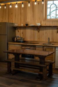 a kitchen with wooden walls and a table and a sink at Feel Funny House in Kʼveda Marghi