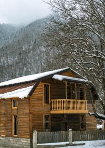 a log cabin with snow on the roof at Feel Funny House in Kʼveda Marghi