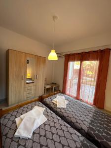 een slaapkamer met een groot bed en een raam bij APARTMENTS 4 YOU in Paliouri