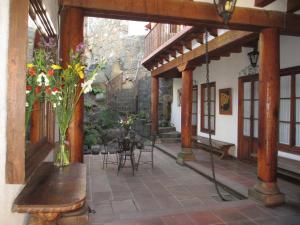 un patio con una mesa y jarrones de flores. en Hotel Estancia de la Era B&B en Pátzcuaro