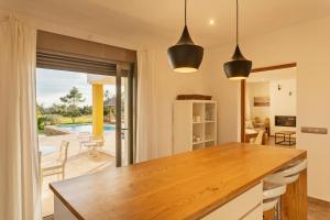 a kitchen with a table and a view of a pool at Villa con piscina Ibiza centro in Sant Josep de sa Talaia