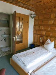 a bedroom with a large bed and a bathroom at Landgasthaus Zum Erlengrund in Emskirchen +1 photo