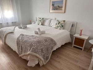 Un dormitorio con una cama grande con dos animales de peluche. en Hotel Consuegra, en Consuegra