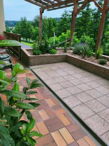 un jardín con un patio de ladrillo y una pérgola en Landgasthaus Zum Erlengrund en Emskirchen