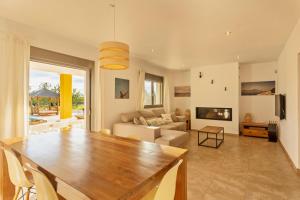a dining room and living room with a wooden table at Villa con piscina Ibiza centro in Sant Josep de sa Talaia