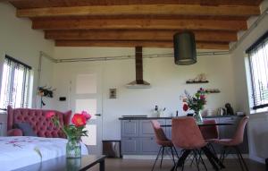 a bedroom with a bed and a table and chairs at Bed & Breakfast Bij de Wilg in Laren