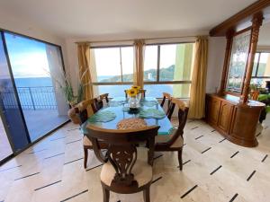 a dining room with a table and chairs and windows at Apartamento Rodadero frente a la playa in Rodadero