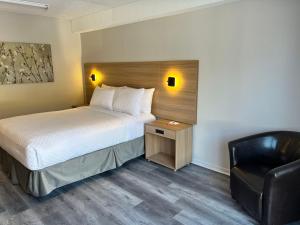 een hotelkamer met een bed en een stoel bij Econo Lodge Airport Quebec in Québec
