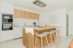 a kitchen with a wooden counter and stools at 7 Cliff Edge in Newquay