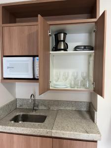 a kitchen with a sink and a microwave at Condomínio Vista Azul in Aracê