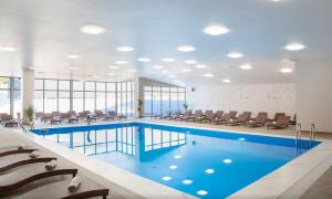 a pool in a hospital with chairs and a large room at Bakuriani Inn - Two Bedroom Suite #332 in Bakuriani