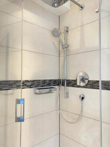 eine Dusche mit Duschkopf im Bad in der Unterkunft Sehr zentral, geräumiges, helles Studio-Apartment in Köln