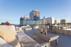 a patio with couches and a table on a roof at 20 Hotel in Punta del Este